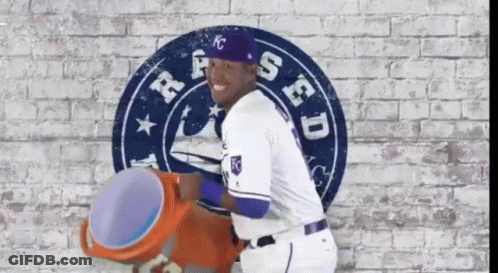 A Baseball Player Is Standing In Front Of A Sign That Says Kc GIF