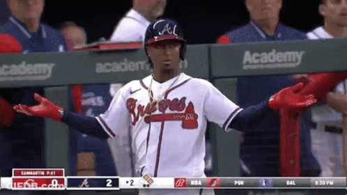 A Baseball Player Is Standing In The Dugout During A Game . GIF