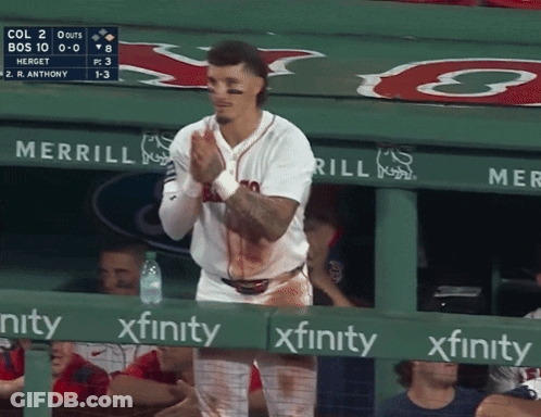 A Baseball Player Is Standing In The Dugout With Blood On His Shirt And A Sign That Says Xfinity GIF
