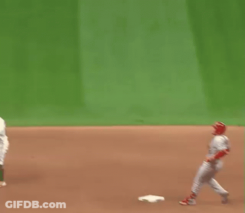 A Baseball Player Is Standing On A Base On A Field . GIF