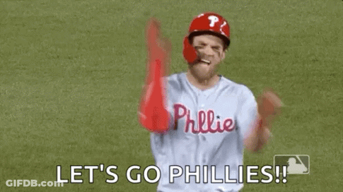 A Baseball Player Is Standing On A Field With His Arms In The Air And Saying `` Let 'S Go Phillies '' . GIF
