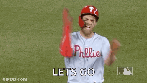 A Baseball Player Is Standing On A Field With His Arms In The Air And Says `` Let 'S Go '' . GIF