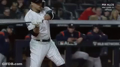 A Baseball Player Is Swinging A Bat At A Ball In A Baseball Game . GIF