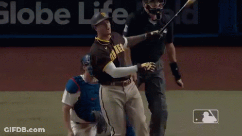 A Baseball Player Is Swinging A Bat At A Ball While A Catcher Looks On . GIF