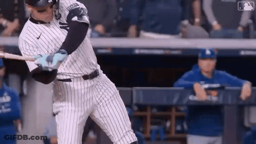 A Baseball Player Is Swinging A Bat At A Pitch During A Baseball Game . GIF