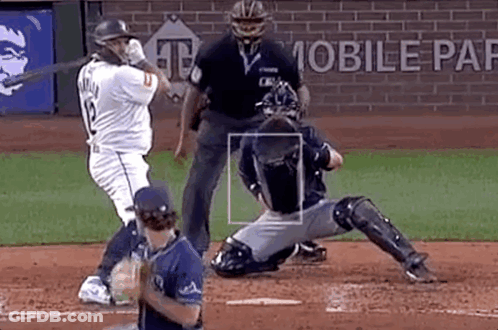 A Baseball Player Is Swinging A Bat At A Pitch While A Catcher Is Sitting On The Base . GIF