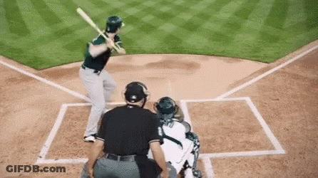 A Baseball Player Is Swinging A Bat At A Pitch While A Catcher Watches . GIF