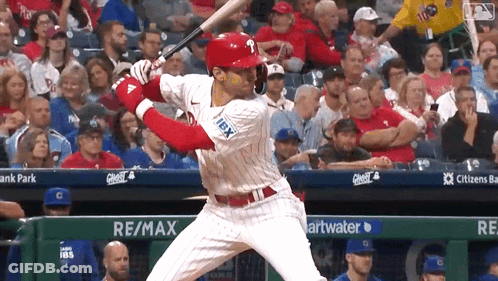 A Baseball Player Is Swinging A Bat In Front Of A Re / Max Banner GIF