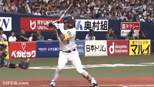 A Baseball Player Is Swinging At A Ball In Front Of A Banner That Says Docomo Business GIF