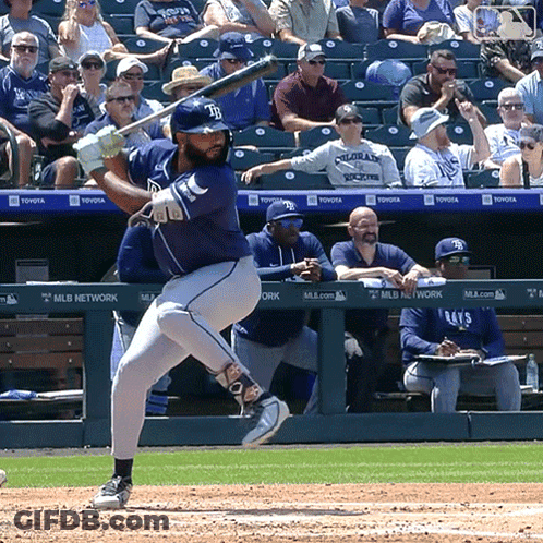 A Baseball Player Is Swinging At A Ball In Front Of A MLB Network Banner GIF