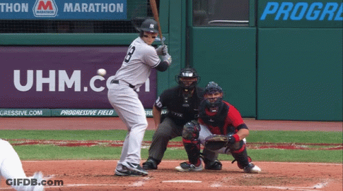 A Baseball Player Is Swinging At A Ball In Front Of An Uhm.com Banner GIF
