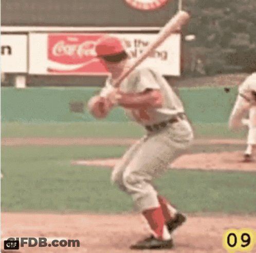 A Baseball Player Is Swinging At A Ball With A Coca Cola Sign In The Background GIF