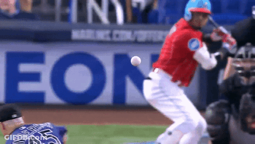 A Baseball Player Is Swinging At A Ball With An Eon Ad In The Background GIF