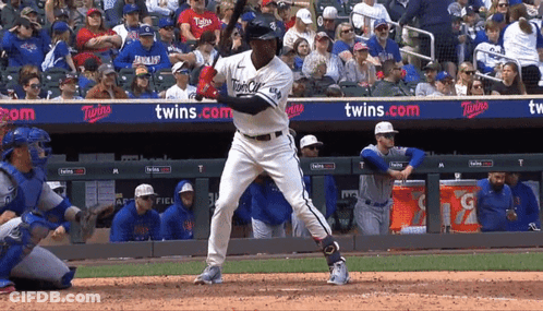 A Baseball Player Is Swinging At A Pitch In Front Of A Banner That Says Twins GIF