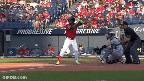 A Baseball Player Is Swinging At A Pitch In Front Of A Progressive Banner GIF