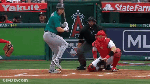A Baseball Player Is Swinging His Bat At A Ball In Front Of A State Farm Ad GIF