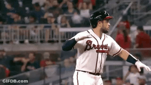 A Baseball Player Is Swinging His Bat At A Ball While Standing On The Field . GIF