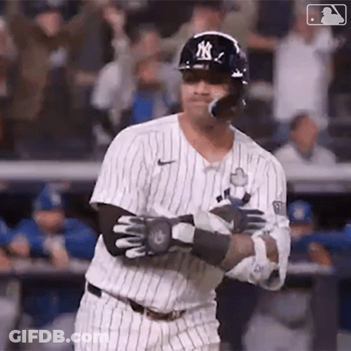 A Baseball Player Is Swinging His Bat At A Ball While Wearing A Helmet And Sunglasses . GIF