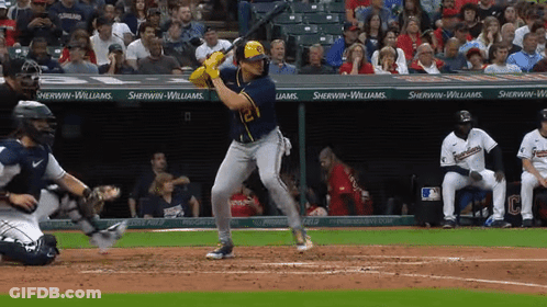 A Baseball Player Is Swinging His Bat At A Pitch In Front Of A Sherwin-Williams Banner GIF