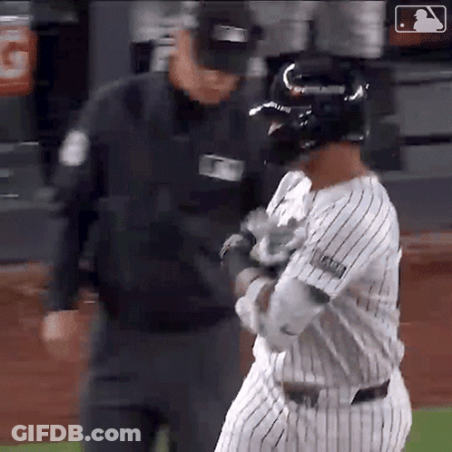 A Baseball Player Is Talking To A Referee While Wearing A Helmet GIF