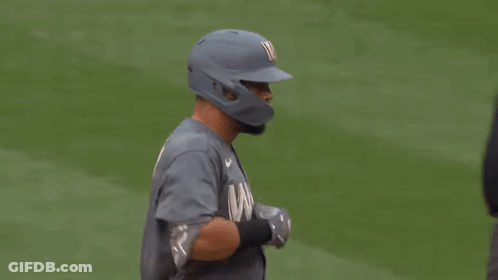A Baseball Player Is Talking To An Umpire While Wearing A Helmet . GIF