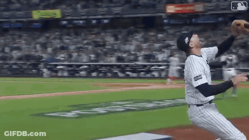 A Baseball Player Is Throwing A Ball In A Stadium With A Sign That Says ' Coca Cola ' On It GIF
