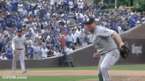 A Baseball Player Is Throwing A Ball To Another Player On A Field . GIF