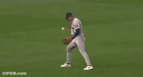 A Baseball Player Is Trying To Catch A Ball On A Field . GIF