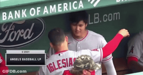 A Baseball Player Named Iglesias Is Hugging Another Player In The Dugout . GIF