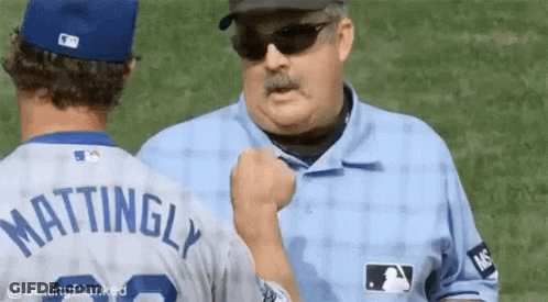 A Baseball Player Named Mattingly Is Shaking Hands With A Referee . GIF