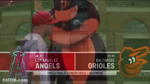 A Baseball Player Standing Next To A Mascot On A Baseball Field . GIF