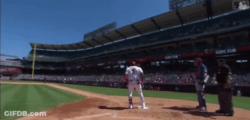A Baseball Player Stands At Home Plate In Front Of A Stadium That Says Home Run On It GIF