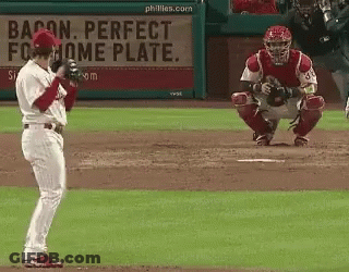 A Baseball Player Stands In Front Of A Bacon Perfect Home Plate Sign GIF
