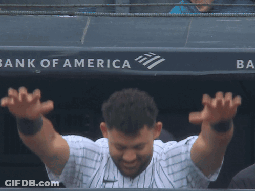 A Baseball Player Stands In Front Of A Bank Of America Sign GIF