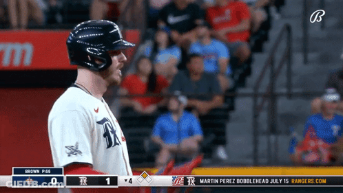 A Baseball Player Stands In Front Of A Scoreboard That Says Rangers.com GIF