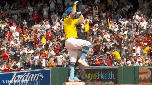 A Baseball Player Stands On A Base In Front Of A Jordan 'S Furniture Advertisement GIF