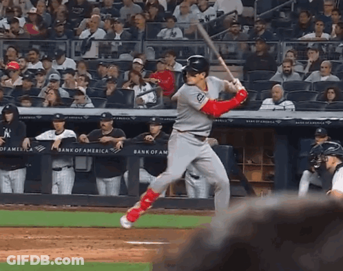 A Baseball Player Swings At A Pitch In Front Of A Bank Of America Sign GIF