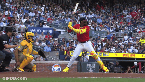 A Baseball Player Swings At A Pitch In Front Of A Gulf Advertisement GIF