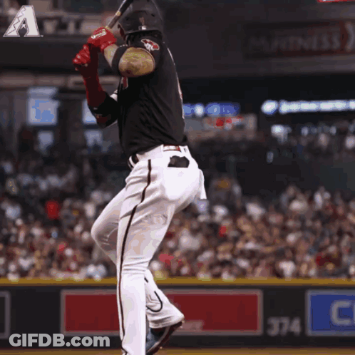 A Baseball Player Swings His Bat At A Ball In Front Of A Sign That Says 374 GIF
