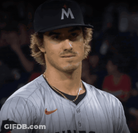 A Baseball Player Wearing A Black Hat With A Letter M On It GIF