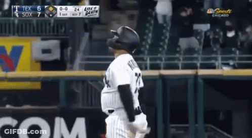 A Baseball Player Wearing A Black Helmet Is Standing On The Field . GIF