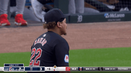 A Baseball Player Wearing A Black Jersey With The Number 22 On It GIF