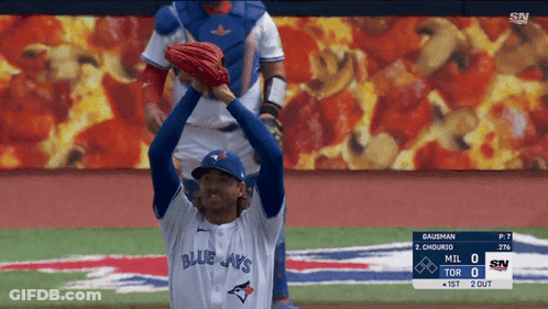 A Baseball Player Wearing A Blue Jays Jersey Stands On A Baseball Field GIF