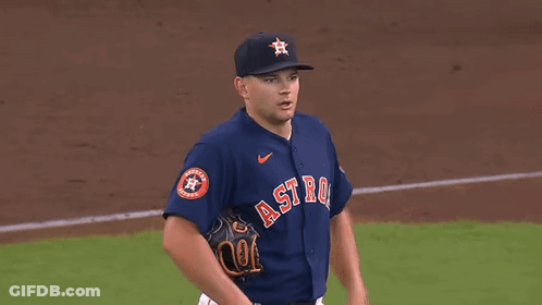 A Baseball Player Wearing A Blue Jersey With The Word Astros On It Is Standing On A Baseball Field . GIF