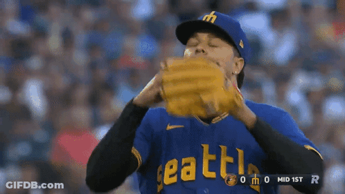 A Baseball Player Wearing A Blue Seattle Jersey Holds His Glove GIF