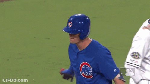 A Baseball Player Wearing A Blue Uniform With A Cubs Logo On It Is Standing On A Field . GIF