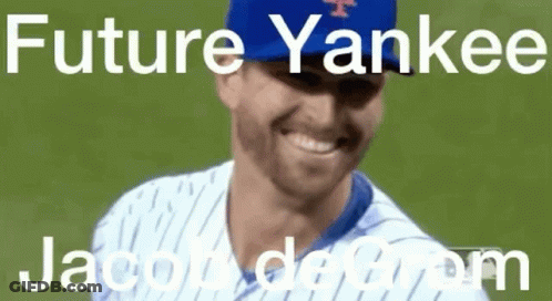 A Baseball Player Wearing A Blue Yankees Hat Is Smiling On A Field . GIF