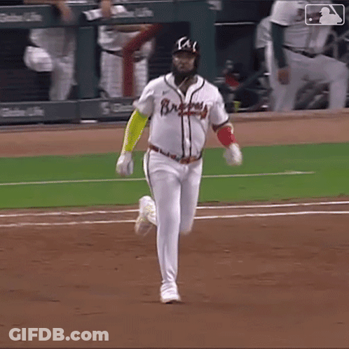 A Baseball Player Wearing A Braves Jersey Is Running Towards Home Plate GIF