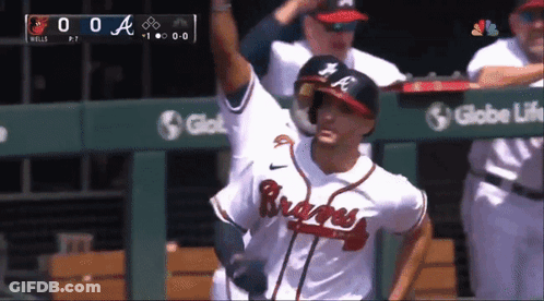 A Baseball Player Wearing A Braves Jersey Stands In Front Of A Globe Life Sign GIF