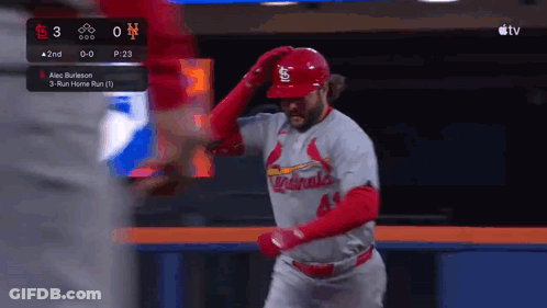 A Baseball Player Wearing A Cardinals Uniform Is Standing In The Outfield . GIF